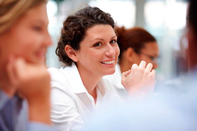 Smiling woman sitting at a business meeting with colleagues